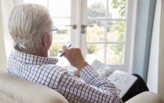 older man sitting with crossword